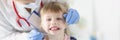 Little girl doctor dentist conducts an examination of oral cavity