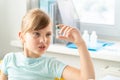 Little girl in doctor`s office looks at vial with vaccine for covid-19 coronavirus,flu,dangerous infectious diseases. Kids plan Royalty Free Stock Photo