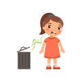 The little girl does not like the bad smell from the trash can