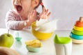 Little girl doesn`t want to eat her breakfast porridge