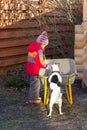 Little girl with dog looking at something in a wheelbarrow Royalty Free Stock Photo