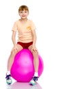 Little girl doing exercises on a big ball for fitness. Royalty Free Stock Photo