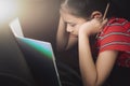 Little girl doing homework on sofa bed under light at home Royalty Free Stock Photo