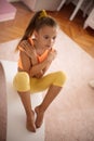 Little girl doing yoga exercise at home on board Royalty Free Stock Photo