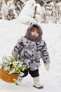 Little girl in a down scarf, a fur coat and valenoks bears a bi