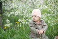 Little girl with Down syndrome in the mouth pulls dandelions