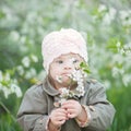 Little girl with Down syndrome smelling flowers Royalty Free Stock Photo