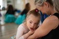 Little girl with down syndrome waiting for ballet class with her mother. Concept of integration disabled children and Royalty Free Stock Photo