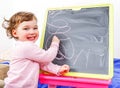 Little girl drawing on blackboard