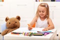 Little girl drawing with color pencils - sitting at the table Royalty Free Stock Photo