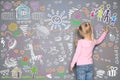 Little girl drawing with colorful chalk on wall