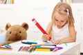 Little girl drawing with a large pencil - sitting at the table Royalty Free Stock Photo