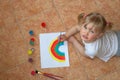 Little girl drawing rainbow. Quarantine fun. Kids paint Royalty Free Stock Photo