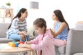 Little girl drawing at table while child psychologist talking Royalty Free Stock Photo