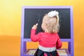 Little girl draws with colored chalk on a children`s school board. The concept of preschool education for children Royalty Free Stock Photo