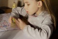 A little girl draws and draws on paper and sharpen a blunt pencil in a sharpener Royalty Free Stock Photo