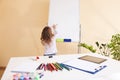 Little girl draws on the white board