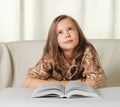 Little girl dreams when reading the book Royalty Free Stock Photo