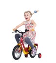 Little girl in a dress with flowers on a bicycle isolated on white background. Royalty Free Stock Photo