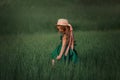 Little girl in dress and hat walking in a green field Royalty Free Stock Photo
