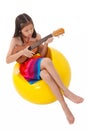 Little girl in dress playing the ukulele Royalty Free Stock Photo