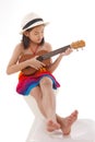 Little girl in dress playing the ukulele Royalty Free Stock Photo