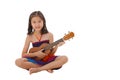 Little girl in dress playing the ukulele Royalty Free Stock Photo