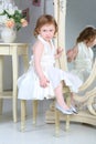 Little girl in dress sitting in front of mirror