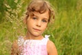 Little girl in dress stands in tall grass Royalty Free Stock Photo