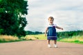 Little girl in dress walking on a country road Royalty Free Stock Photo