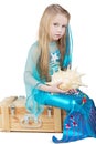 Little girl dressed as mermaid sits with seashell