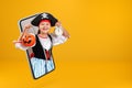 A little girl dressed as a pirate for Halloween holds a bucket with a pumpkin lantern and an alarm clock. Royalty Free Stock Photo