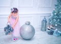 Little girl dressed in beautiful fashion white flower dress posing near Christmas tree Royalty Free Stock Photo