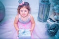 Little girl dressed in beautiful fashion white flower dress posing near Christmas tree Royalty Free Stock Photo