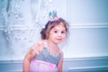 Little girl dressed in beautiful fashion white flower dress posing near Christmas tree Royalty Free Stock Photo