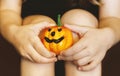 A little girl dressed in a witch costume for Halloween holds a pumpkin lantern in her hands close-up. A Child Holds Jack`s Pumpkin Royalty Free Stock Photo