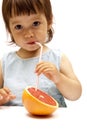 Little girl drinking a grapefruit juice Royalty Free Stock Photo