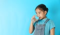 Little girl drinking water on blue background Royalty Free Stock Photo