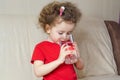 Little girl drinks clean spring water from glass. child quenches thirst with aqua at home