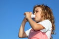 Little girl drinks yoghurt from small bottle