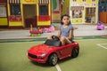 Little girl driving mini car at an amusement park. Royalty Free Stock Photo