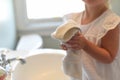Little girl drying hands on a towel in bright morning light Royalty Free Stock Photo
