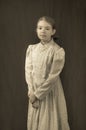 Little girl in early 20th century clothing in replica antique photograph