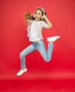 Little girl in earphones. reach her dream. jump up in air. achievement. ecstatic little girl wear earphones. show dance