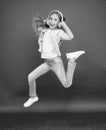 Little girl in earphones. reach her dream. jump up in air. achievement. ecstatic little girl wear earphones. show dance