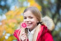 Little girl eat candy on stick, food. Child smile with lollipop, snack. Food, snack, dessert for small child on nature. Happy chil