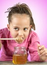 Little girl eat honey Royalty Free Stock Photo