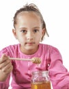 Little girl eat honey Royalty Free Stock Photo
