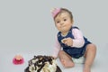 Little girl eating cake, ten months old, big cake for the holiday Royalty Free Stock Photo