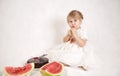 Little girl eating a cake and watermelon Royalty Free Stock Photo